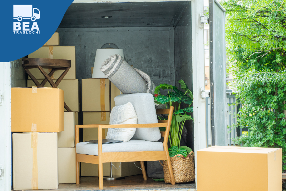Scatoloni, mobili e piante sistemati ordinatamente all'interno di un furgone per trasloco, pronti per essere trasportati in estate.
